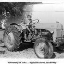 Wesley and Ray Maynard on tractor at Birkby farm, Shenandoah, Iowa, 1950s