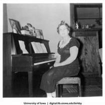 Myrtle Brooks, friend and neighbor to Evelyn Birkby, at her piano, Shenandoah, Iowa, 1950s?